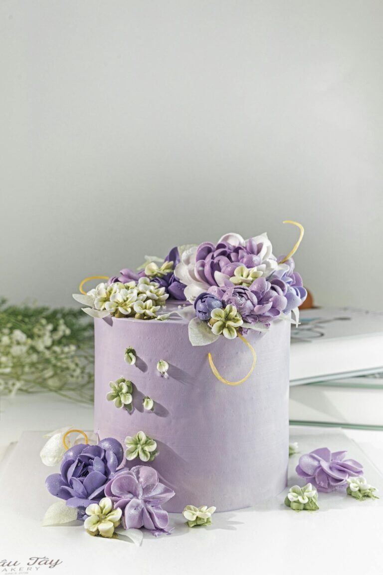 Beautiful purple cake adorned with intricate icing flowers, perfect for celebrations.